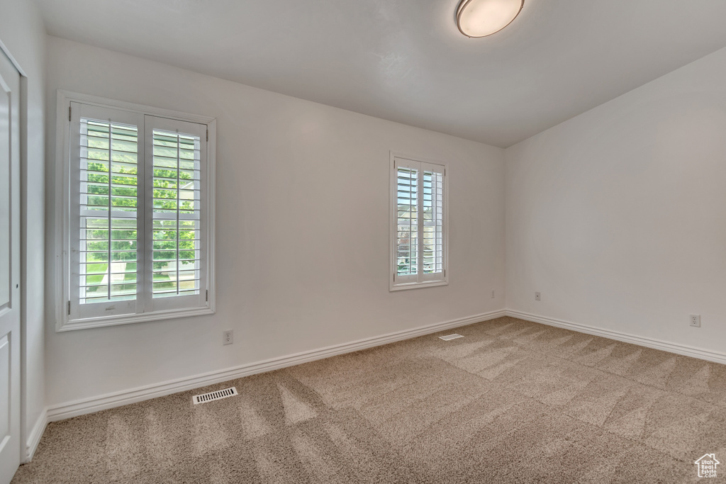 Carpeted spare room featuring baseboards