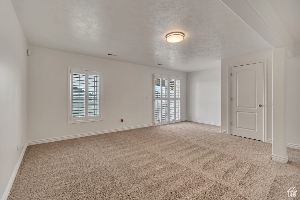 Carpeted empty room featuring baseboards