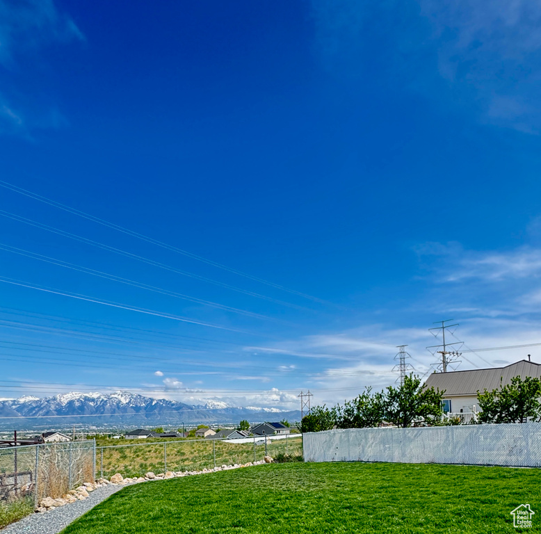 View of yard with a mountain view and fence