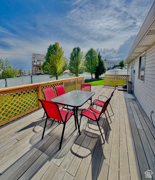 Wooden terrace with outdoor dining space and fence