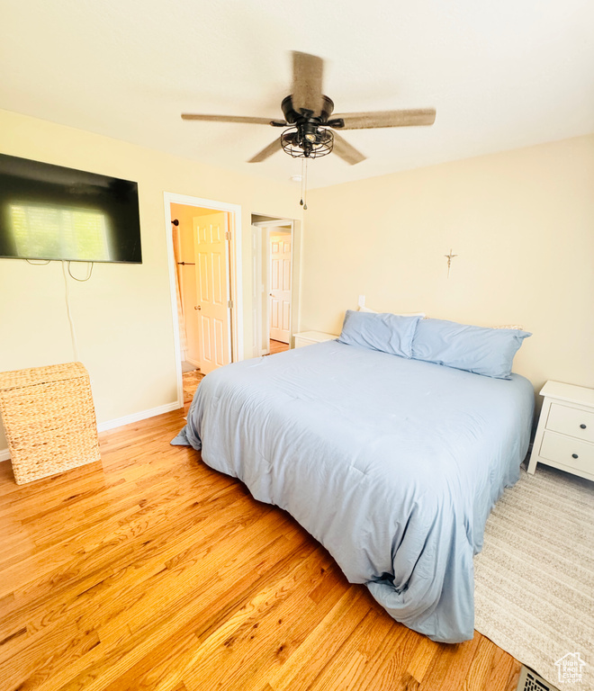 Bedroom with baseboards, light wood-type flooring, and a ceiling fan