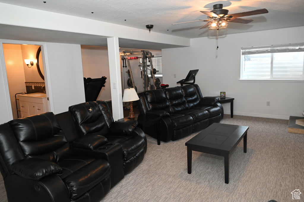 Carpeted living room with baseboards and ceiling fan