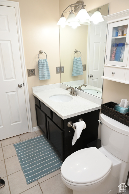 Bathroom featuring toilet, tile patterned flooring, and vanity