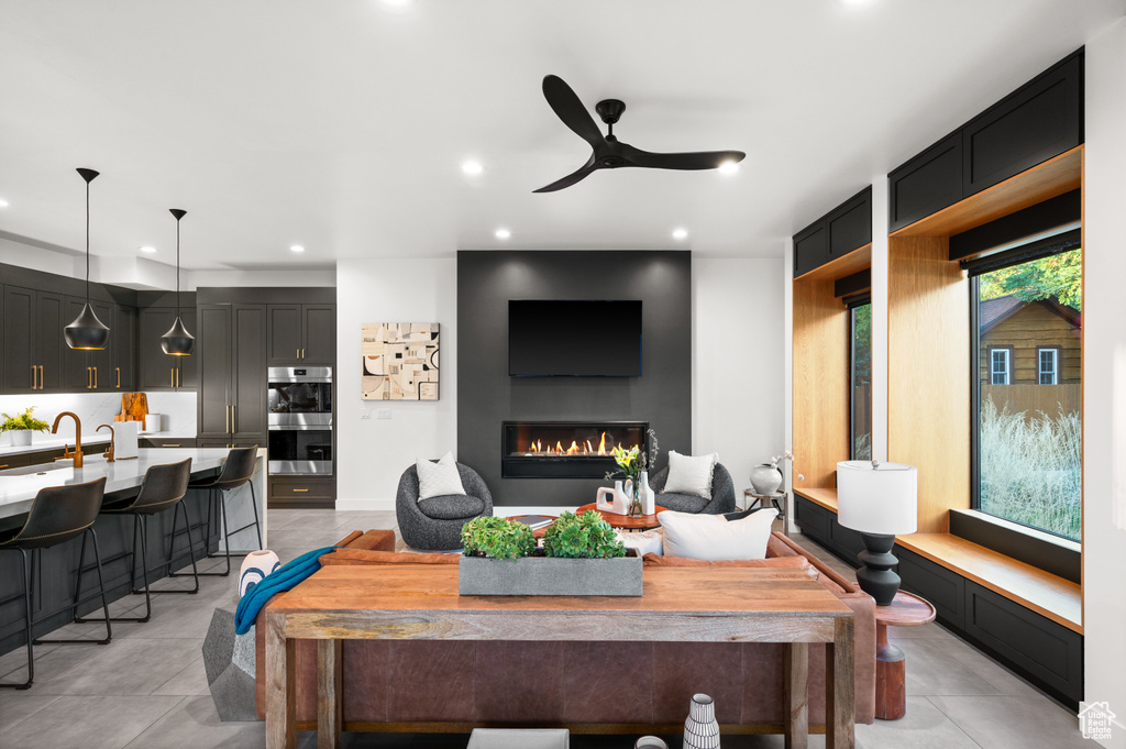 Living area featuring recessed lighting, ceiling fan, and a glass covered fireplace