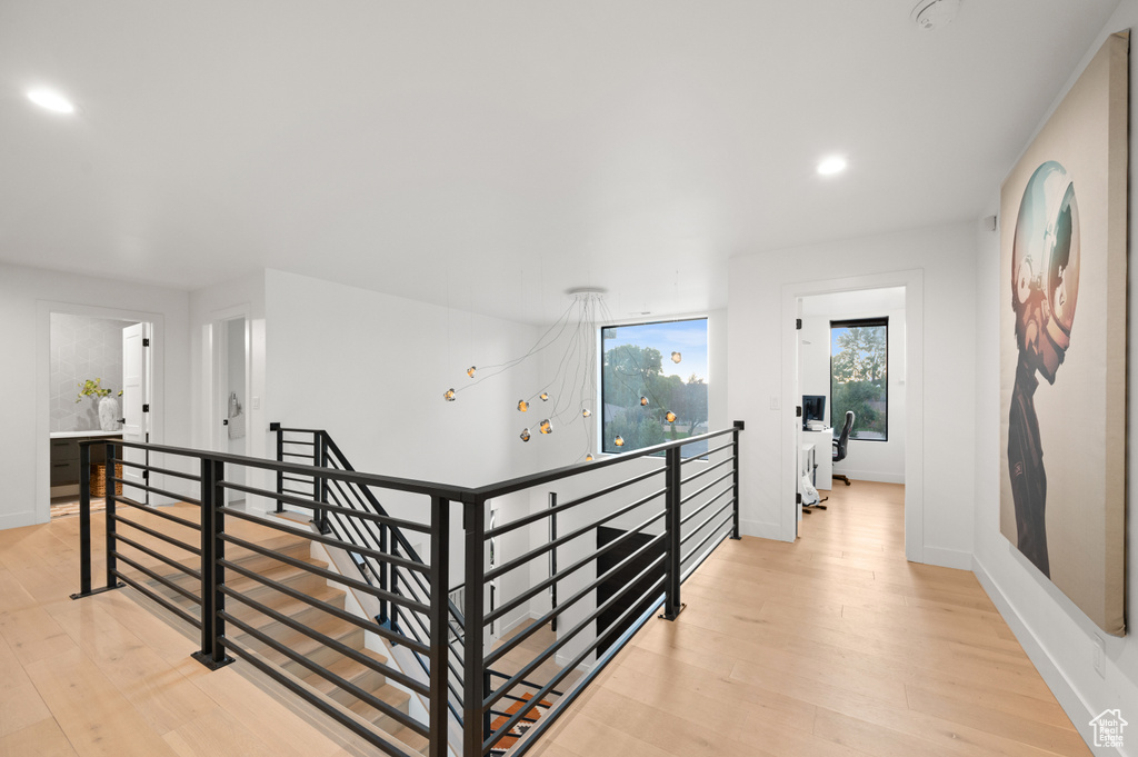 Hallway featuring an upstairs landing, light wood-type flooring, recessed lighting, and baseboards