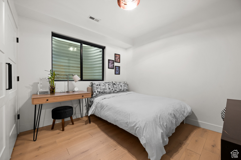 Bedroom with baseboards, visible vents, and wood-type flooring