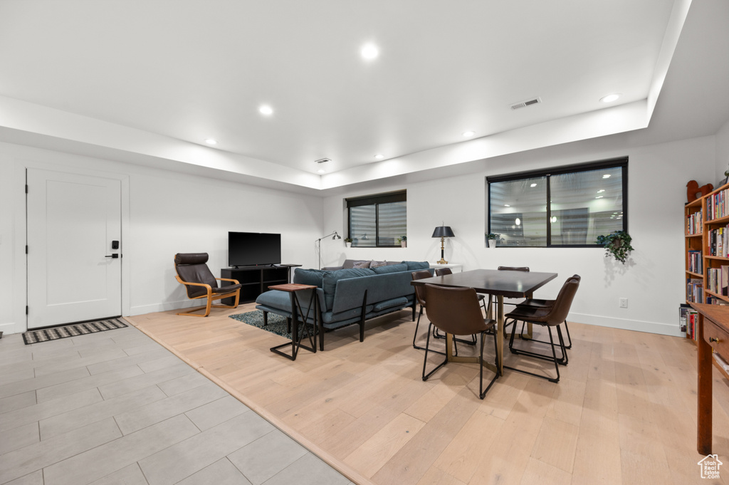 Dining room featuring light wood-style flooring, visible vents, a tray ceiling, baseboards, and recessed lighting