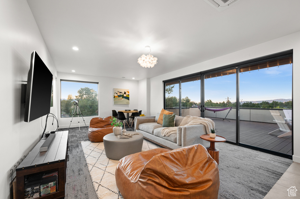 Living area with baseboards, recessed lighting, and an inviting chandelier