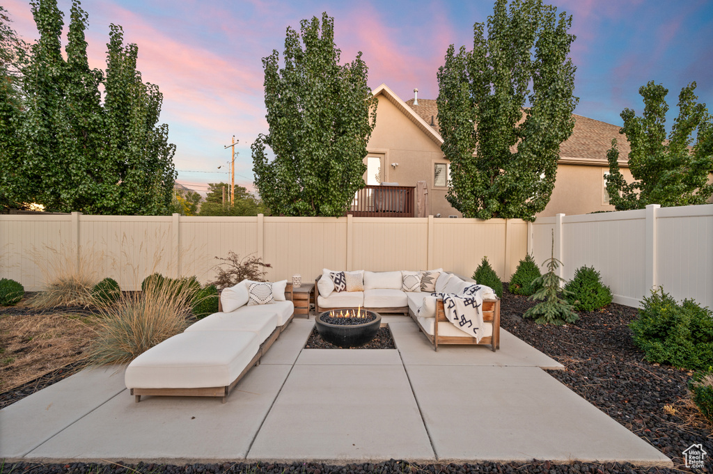 View of patio with an outdoor living space with a fire pit and a fenced backyard