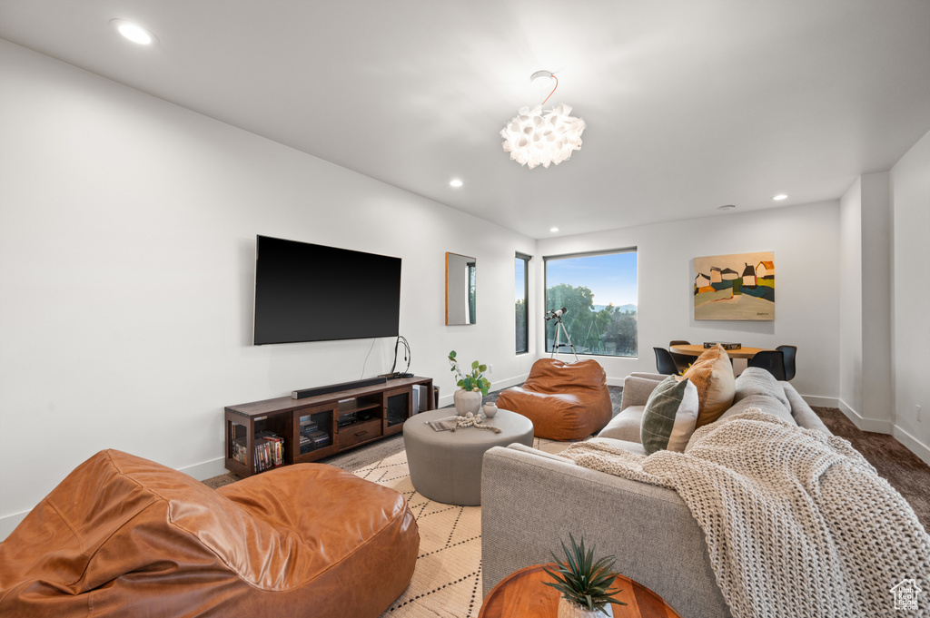 Living area featuring recessed lighting, a notable chandelier, and baseboards