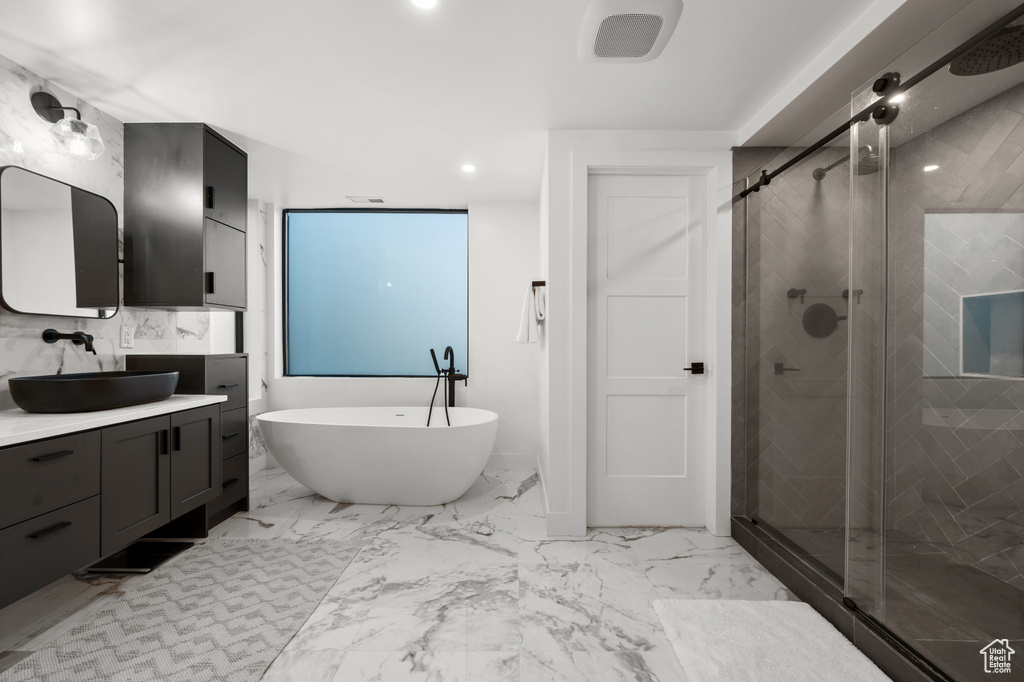 Bathroom with a soaking tub, recessed lighting, a stall shower, and vanity