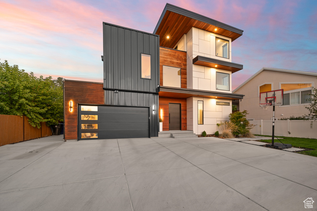 Modern home with fence, driveway, and an attached garage
