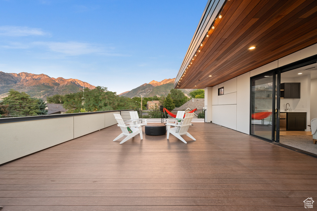 Wooden terrace featuring a mountain view and a sink