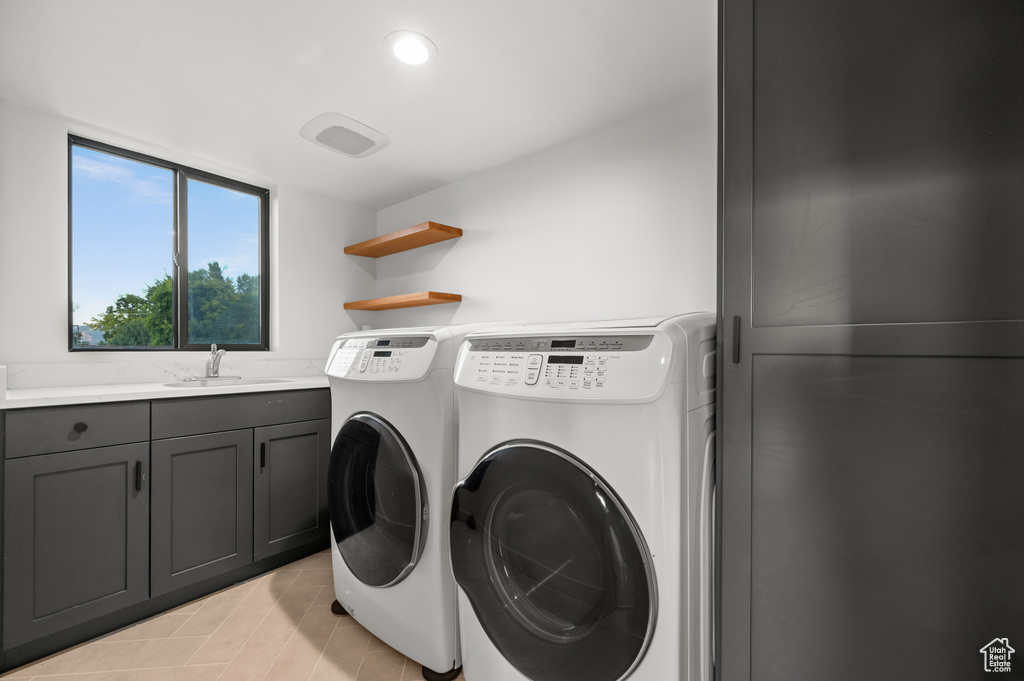Laundry area featuring recessed lighting, washer and dryer, cabinet space, and a sink