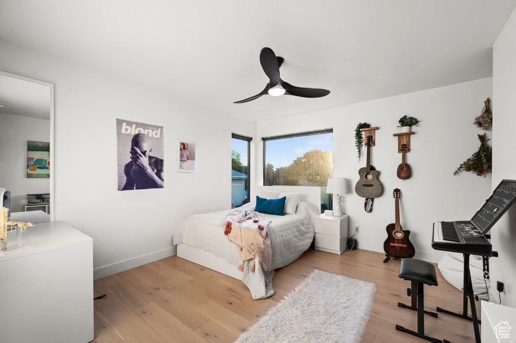Bedroom featuring baseboards, a ceiling fan, and light wood-style floors