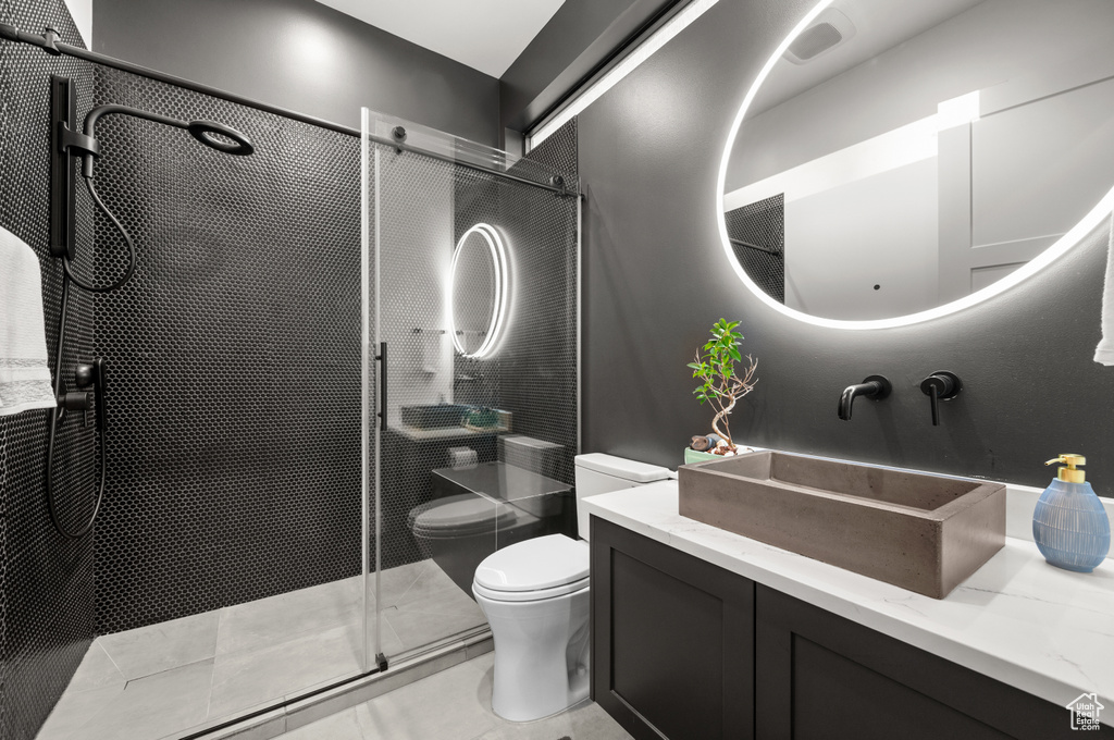 Bathroom featuring tile patterned floors, a shower stall, toilet, and vanity