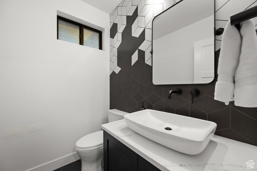 Bathroom with vanity, toilet, and baseboards