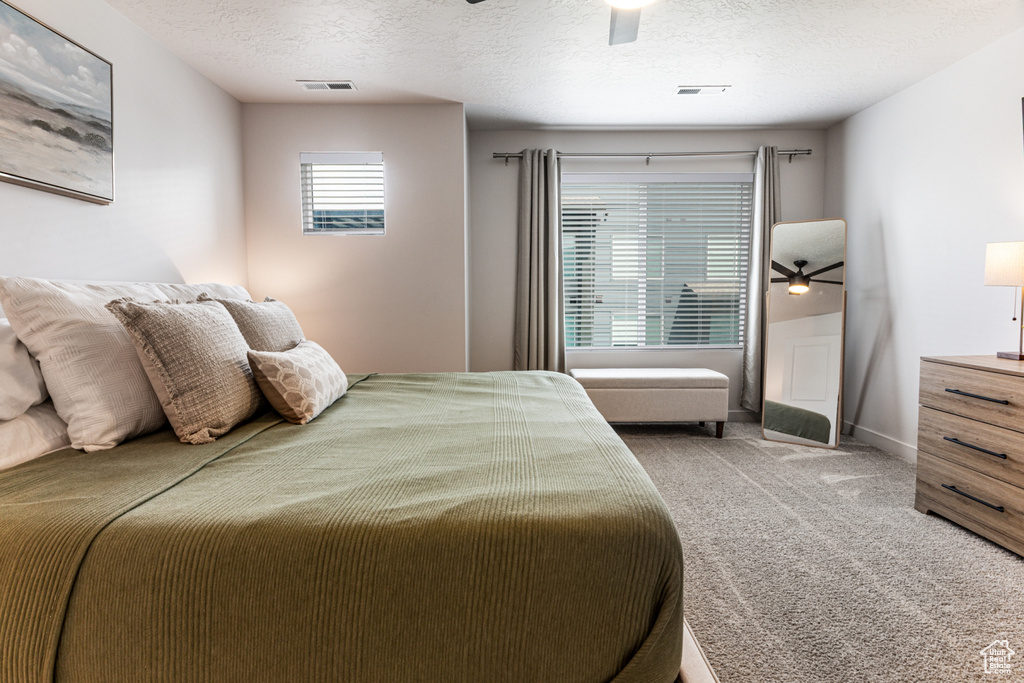 Bedroom featuring carpet, a textured ceiling, ceiling fan, and baseboards
