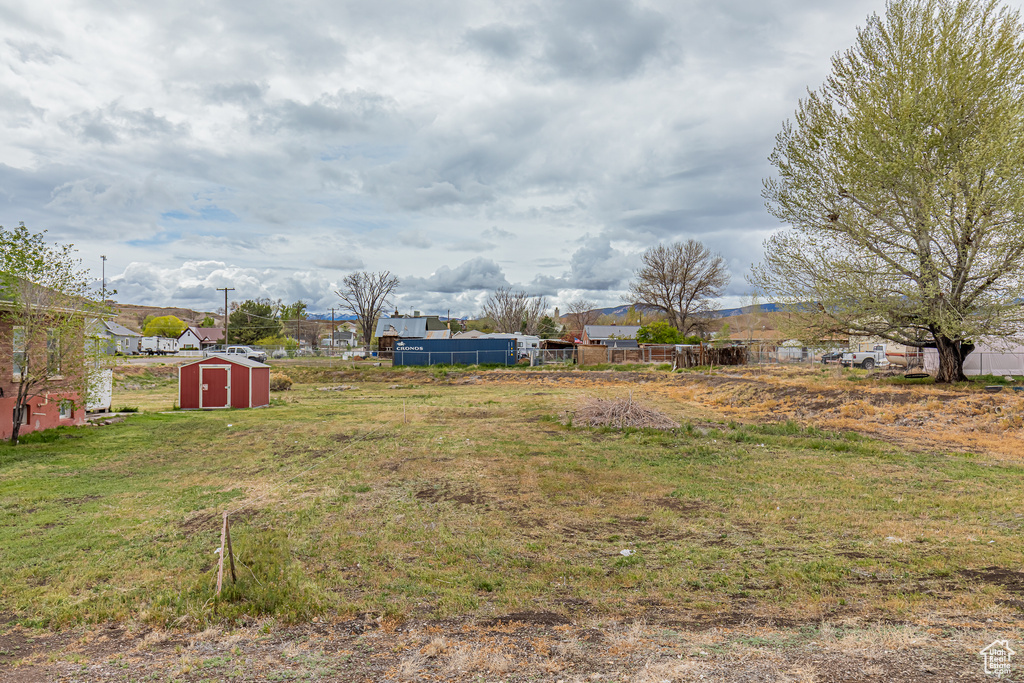 View of yard with a storage unit and an outbuilding