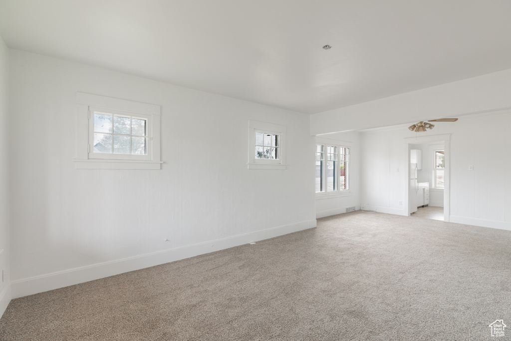 Empty room with light colored carpet and baseboards