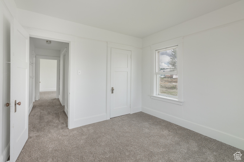 Unfurnished bedroom featuring carpet, baseboards, and a closet