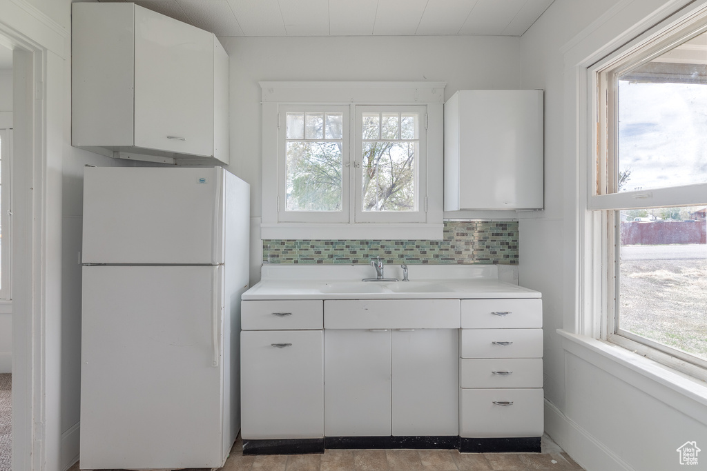 Kitchen with freestanding refrigerator, healthy amount of natural light, and a sink