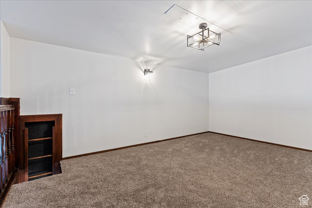 Carpeted spare room featuring baseboards