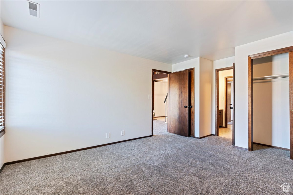 Unfurnished bedroom with carpet and baseboards