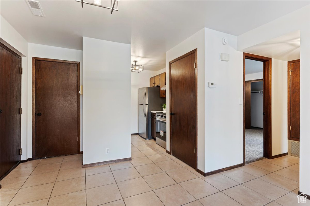 Kitchen featuring light tile patterned floors, stainless steel appliances, baseboards, and light countertops