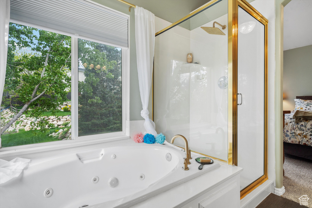 Bathroom with ensuite bath, a stall shower, and a whirlpool tub