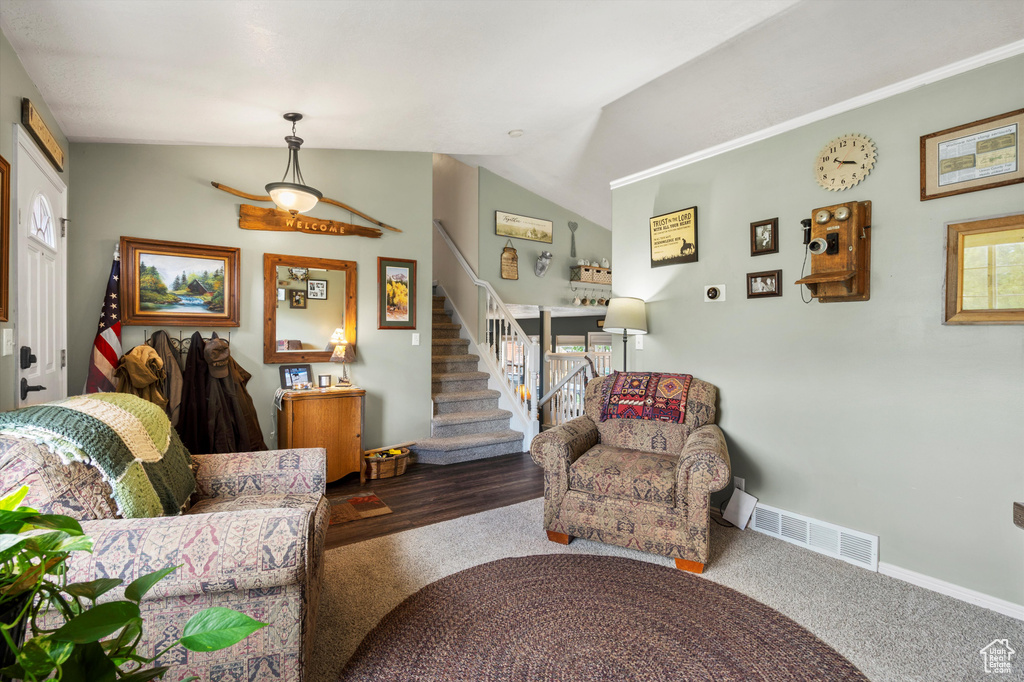 Living area featuring stairway, lofted ceiling, and baseboards