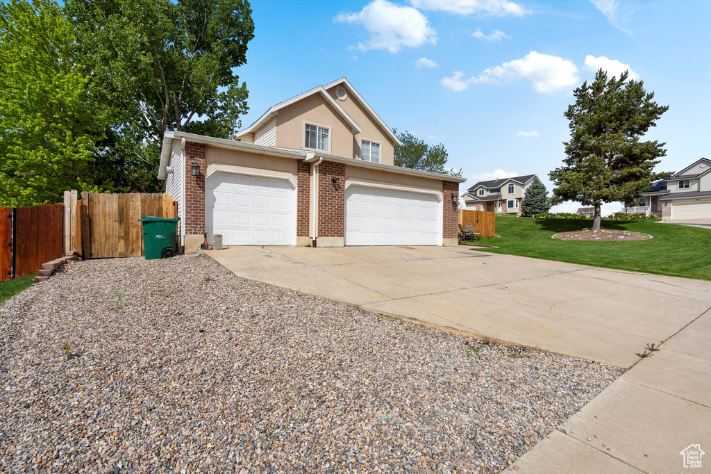 Traditional-style home with brick siding, an attached garage, and driveway