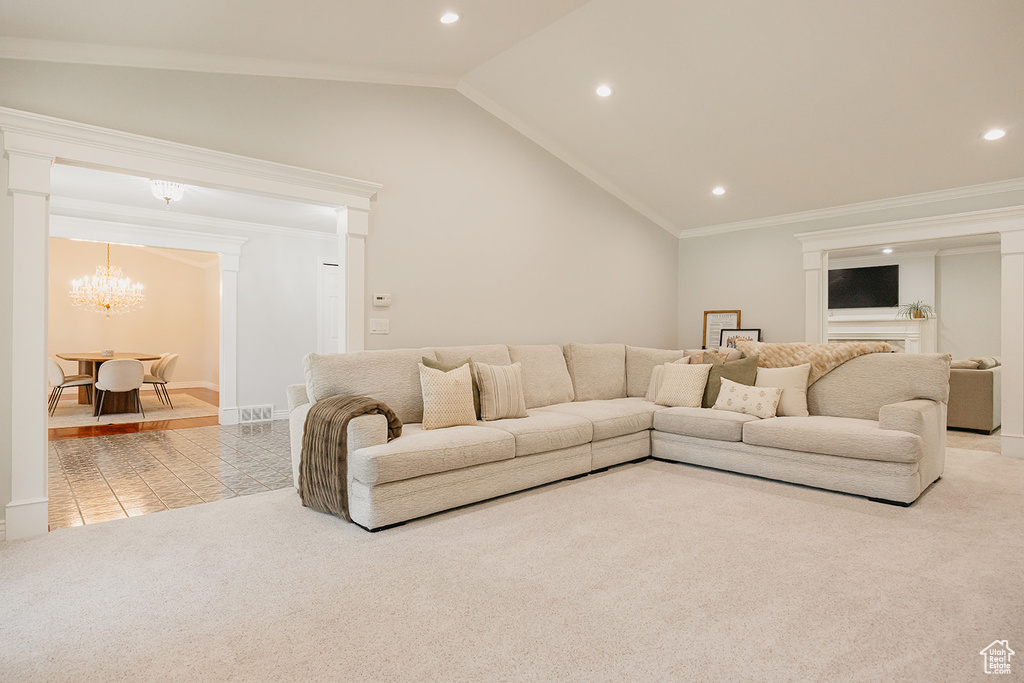Carpeted living room with lofted ceiling, recessed lighting, ornamental molding, tile patterned flooring, and a chandelier