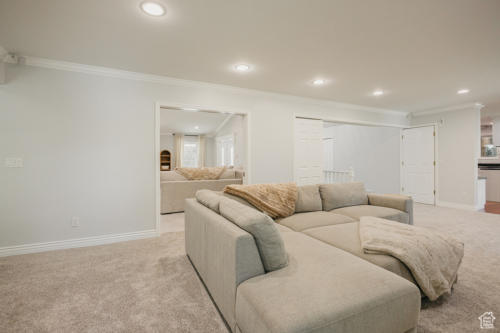 Living room with ornamental molding, light carpet, and recessed lighting
