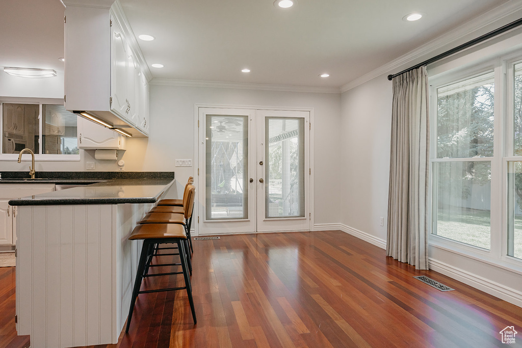 Kitchen with white cabinets, dark countertops, visible vents, and french doors