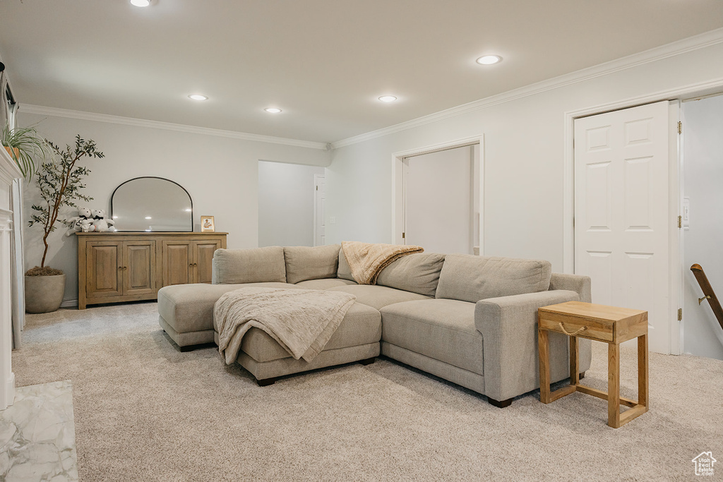 Living area with light colored carpet, ornamental molding, and recessed lighting