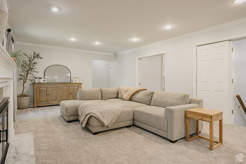 Living area with light carpet, ornamental molding, and recessed lighting