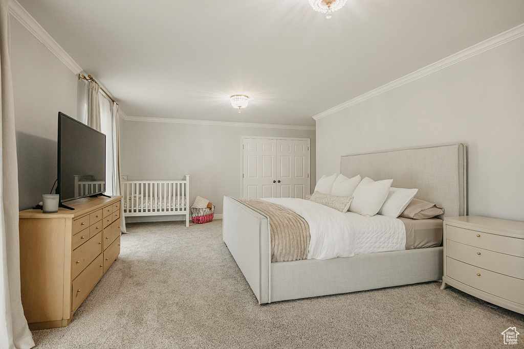 Bedroom featuring light carpet, ornamental molding, and a closet