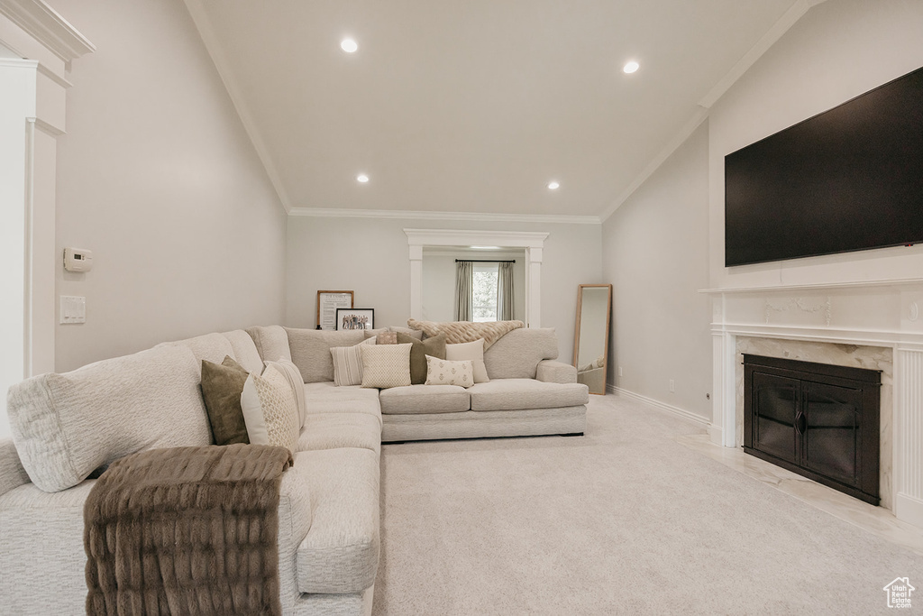 Living area featuring vaulted ceiling, ornamental molding, a high end fireplace, and recessed lighting