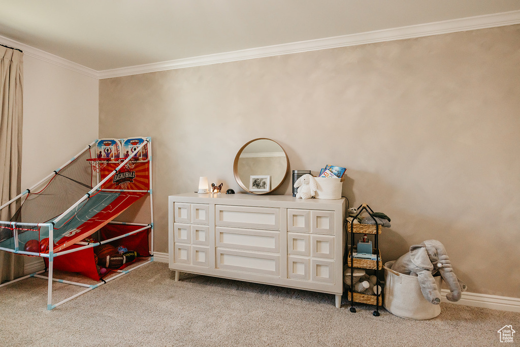 Game room with ornamental molding, light carpet, and baseboards