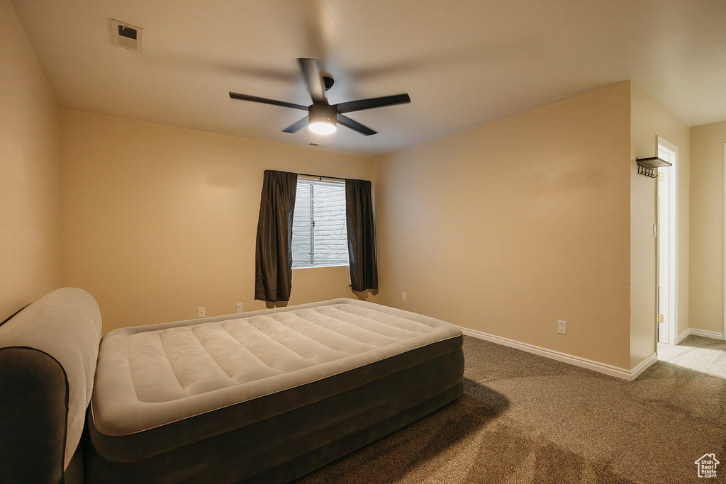 Carpeted bedroom featuring visible vents, baseboards, and a ceiling fan
