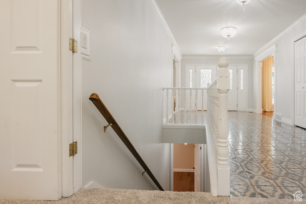 Staircase with visible vents, baseboards, and ornamental molding