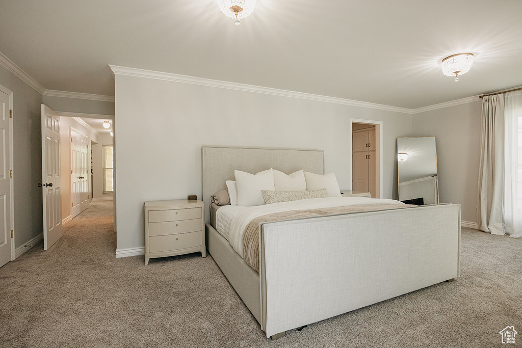 Bedroom with baseboards, ornamental molding, and light colored carpet