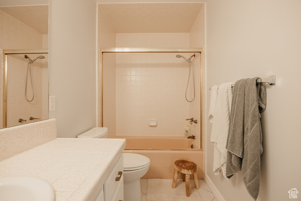 Full bathroom featuring toilet, tile patterned floors, vanity, and shower / washtub combination
