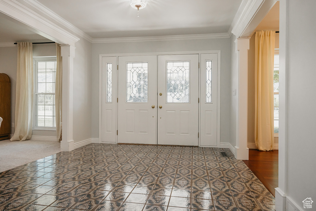 Entrance foyer featuring ornamental molding and baseboards