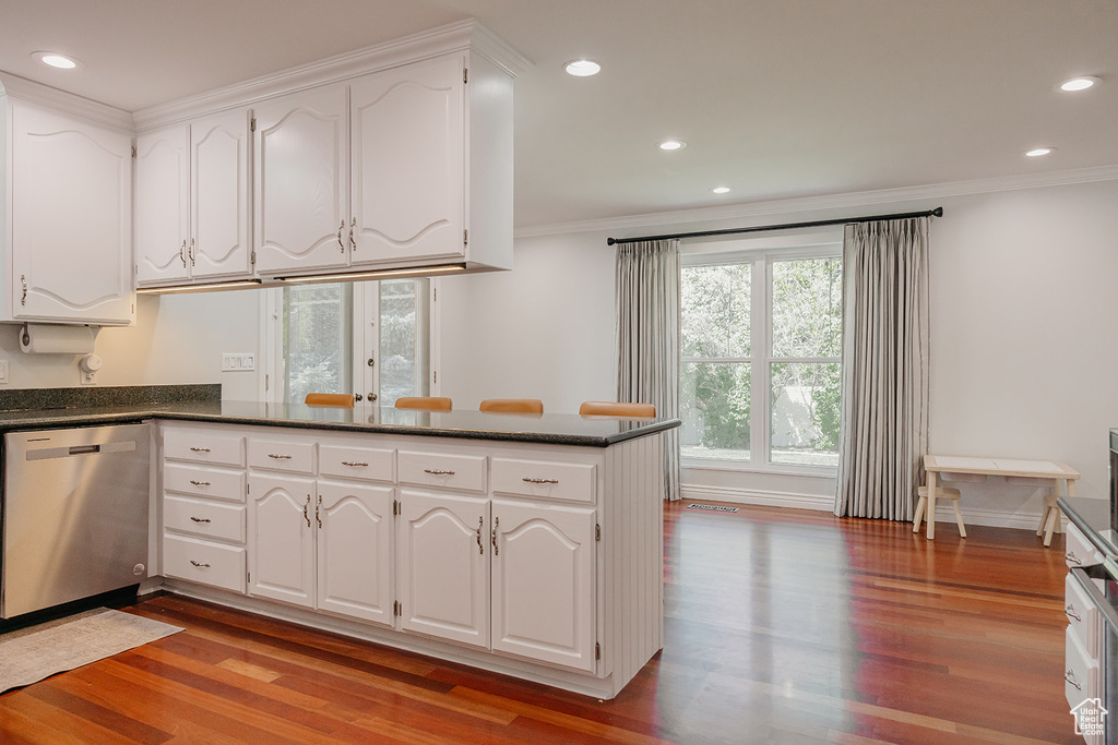 Kitchen featuring white cabinetry, light wood finished floors, crown molding, and dishwasher