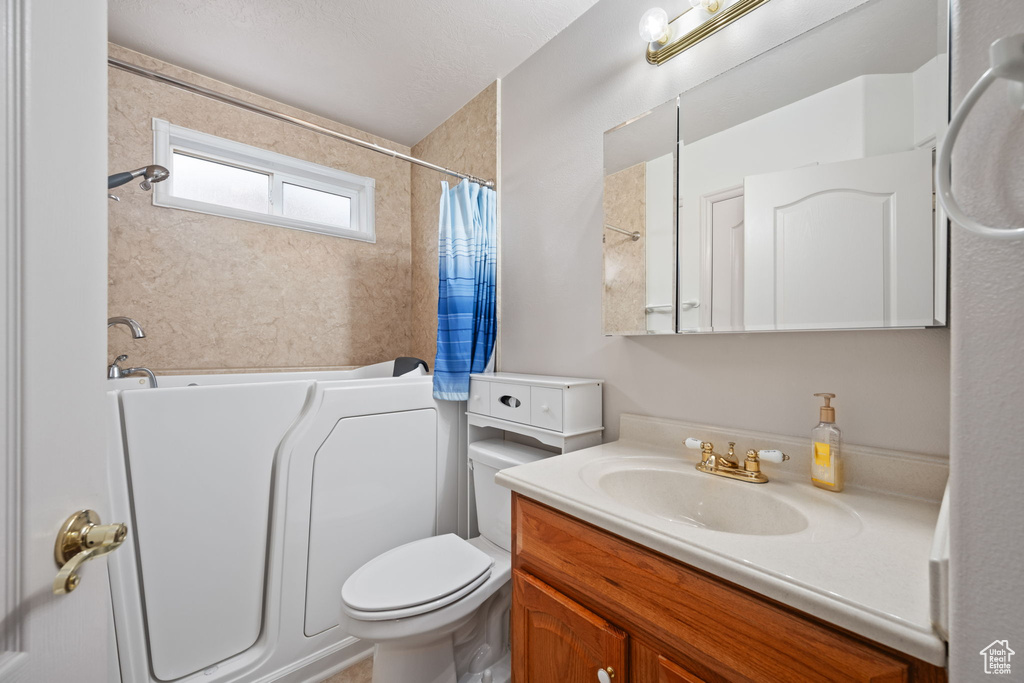Full bathroom with a bath, toilet, a shower with shower curtain, and vanity