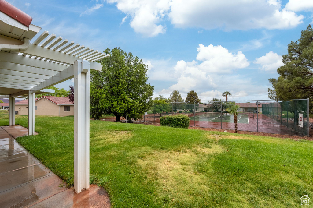 View of yard featuring a tennis court and a pergola
