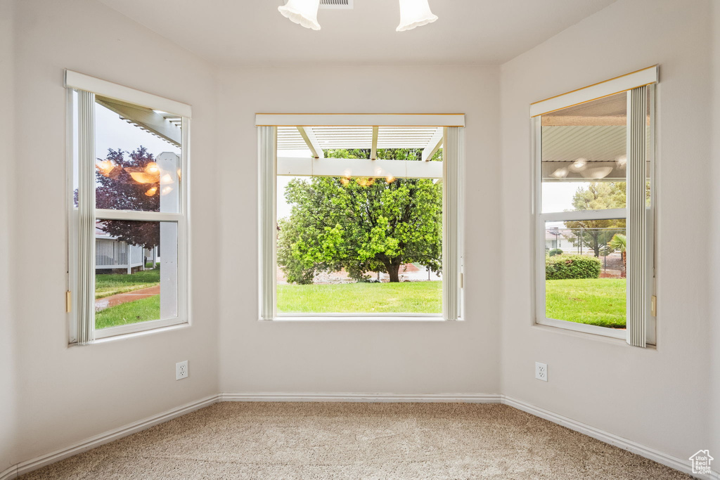 Spare room featuring carpet floors and baseboards