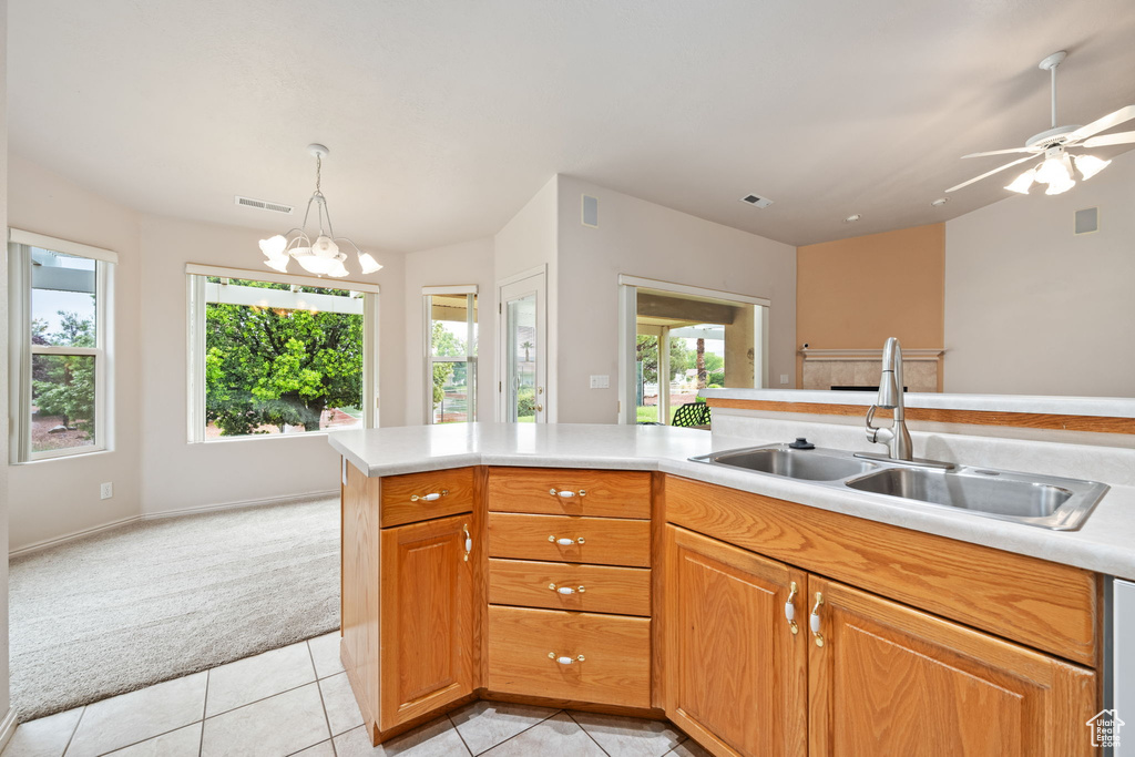 Kitchen featuring light colored carpet, a sink, light countertops, and healthy amount of natural light